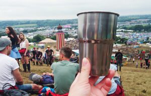 A shot of a stainless steel cup with Glastonbury in the background
