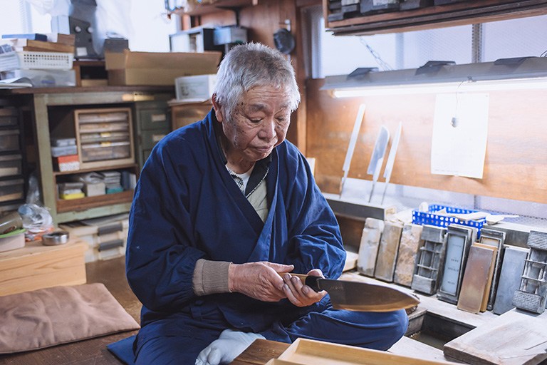 A master blacksmith places on of his sushi knives into a presentation box