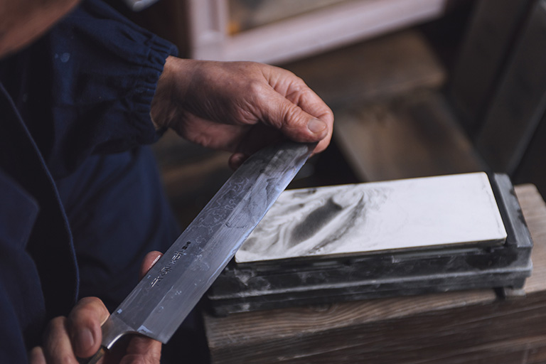 Master Blacksmith Tokifusa Izuka sharpening a sushi knife