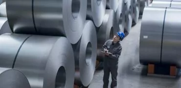 Worker inspecting cold rolled coils in storage yard. Tangsteel. Tangshan, China.