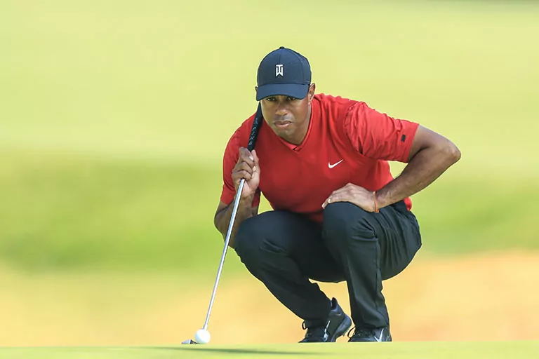 Tiger Woods prepares to make a putt with his steel golf club